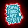 A neon sign with colorful letters reading "Swim Hard Eat Often" in bold, futuristic font.
