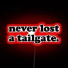 Neon-lit tailgate party sign with bold, red letters in a modern design