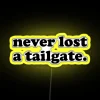 Neon sign reading 'Tailgate Party' with colorful, glowing letters against a dark background.