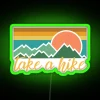 A neon sign reading 'Take A Hike' in bold, green letters.
