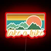 RGB neon sign with hiking trail in bold red letters.