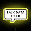 Neon sign reading "Talk Data to Me" in yellow letters on a dark background.