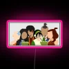 Group of friends posing together in front of a neon pink sign with RGB lighting effects.