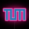 Technical University of Munich logo illuminated in neon colors at night.