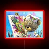 A colorful neon sign with a teddy bear design