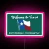 Neon sign of Texas state logo on a drive friendly road in a pink hue.