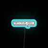 Glowing neon sign with bold, cursive letters reading "That's rough, buddy" in bright blue colors.