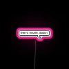 Neon sign with pink, blue, and green lights spelling out 'That's Rough Buddy'