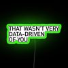 Neon sign with bold, green letters criticizing a lack of data-driven decision making.