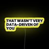 Neon sign with yellow lettering criticizing lack of data-driven decision making.