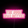 Neon sign reading 'The Book Was Better' in bold pink letters.