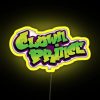 Vibrant neon sign of a clown's face with a mischievous grin, set against a dark background.