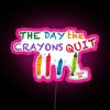Neon sign with pink letters reading 'The Day The Crayons Quit'