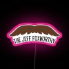 Jeff Foxworthy neon sign in pink and purple hues, reflecting off a city street at night.