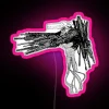 Neon pink sign featuring a cartoonish depiction of a gun-wielding devil character.