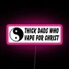 Neon sign with bold, cursive font reading 'Thick Dads 4 Christ' in pink and blue hues.
