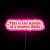 Neon sign reading 'This is the kind of reader I am, Bella - Funny books' in pink and RGB colors.