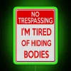 Neon sign with bold, colorful letters spelling out 'Tired of Hiding Bodies'