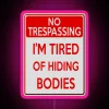 Bright neon sign with pink letters spelling out 'Tired of Hiding Bodies'
