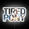 Tired pony in front of a colorful neon sign