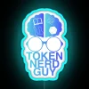 A young man with glasses, wearing a graphic t-shirt, sitting in front of a colorful neon sign that reads "Token Nerd Guy"...
