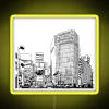 Neon sign in Tokyo's Shibuya district at sunset, displaying vibrant yellow hues.