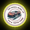 Neon-lit Corvette sign with vibrant RGB colors against a dark background, showcasing the car's sleek design.