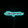 Neon Toyota Supra GR logo illuminated on a blue sign