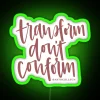 Neon sign reading "Transform, don't conform" in green letters on a dark background.