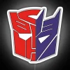 Autobots vs Decepticons in vibrant neon colors on a digital sign.