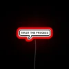 Neon sign with bold, glowing letters reading 'Trust The Process'