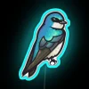 Colorful tree swallow perched on a neon sign