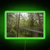 Rainforest treetop walkway with vibrant neon green accents.