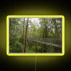 Tropical rainforest canopy walkway with vibrant neon lighting in the evening