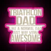 Triathlon dad with neon sign and triathlete gear, embracing fatherhood in a sporty way.