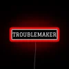 Neon sign reading 'Troublemaker' in bold, red letters.