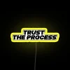 Neon sign with colorful, glowing letters reading 'Trust The Process'