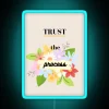 Neon sign with blue letters reading 'Trust The Process'