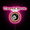 Tropical neon sign with pink lettering, reading 'Tweek Bros Coffee'