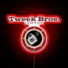 Neon sign reading "Tweek Bros Coffee" in bold, colorful letters with a futuristic RGB glow effect.