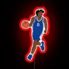 Philadelphia 76ers point guard Tyrese Maxey posing in front of an RGB neon sign with red lighting, highlighting his jersey...