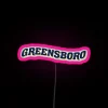 UNC Greensboro campus neon sign with pink accents.