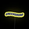 UNCG University of North Carolina at Greensboro RGB neon sign illuminated against a dark background.