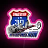 Retro US Route 30 drag strip neon sign in pink hue at night