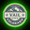A neon green sign with colorful lighting effects in Vail, Colorado.