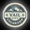 Neon sign reading 'Vail Colorado' in bold, colorful letters against a dark background.