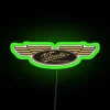 Velocette motorcycle logo in neon green on a colored background.