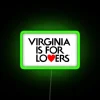 Neon "Virginia is for Lovers" sign in colorful RGB lighting against a green background.