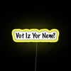 Neon sign reading "Vote or Die Now" in bright yellow color with a futuristic aesthetic.
