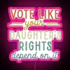 Neon sign with bold, colorful letters reading 'Vote like your daughter's rights depend on it'